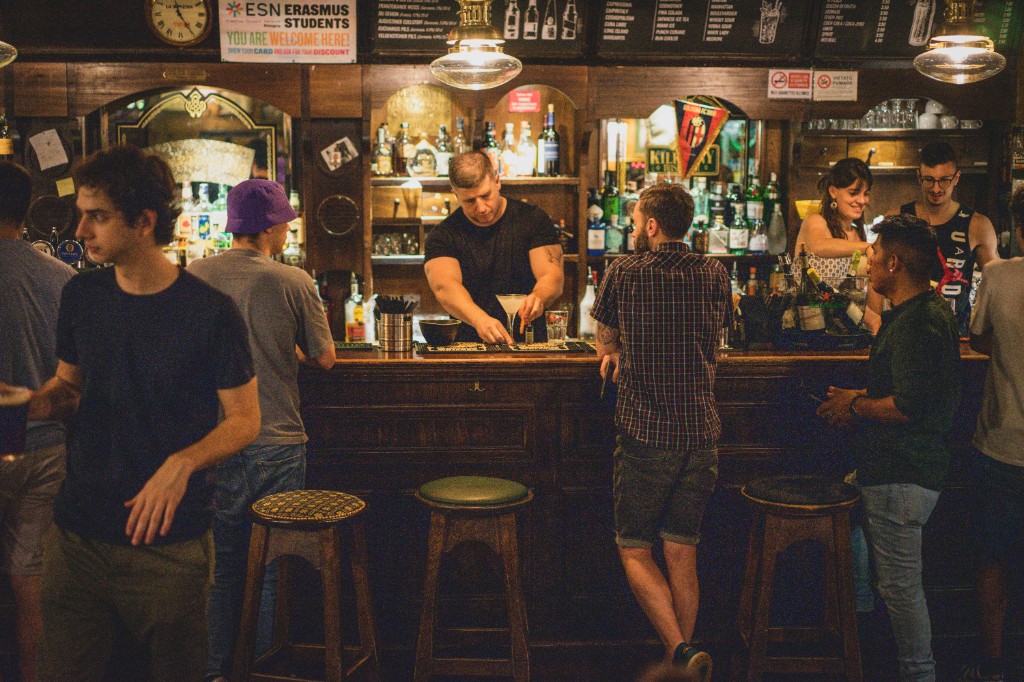 Bartender pouring drinks at a busy bar