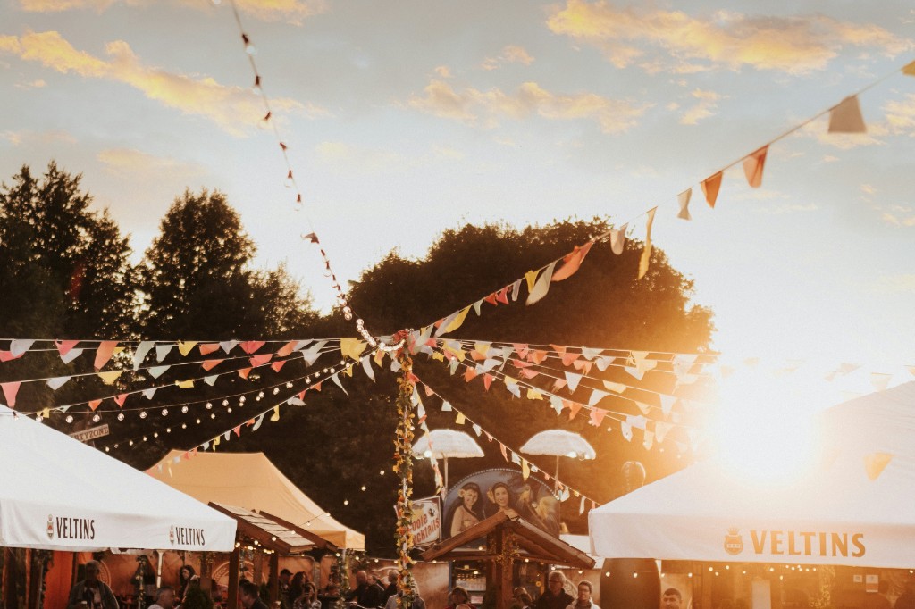 Outdoor festival with bunting and beer tents at sunset